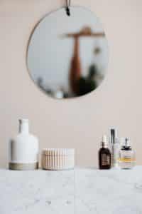 There are cosmetic products on marble shelves with a cream bottle for male reproductive organ expansion.