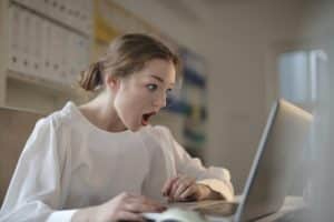 An image of an impressed woman after looking at large penis size images on her laptop illustrates that you can impress any woman when you make your penis grow.